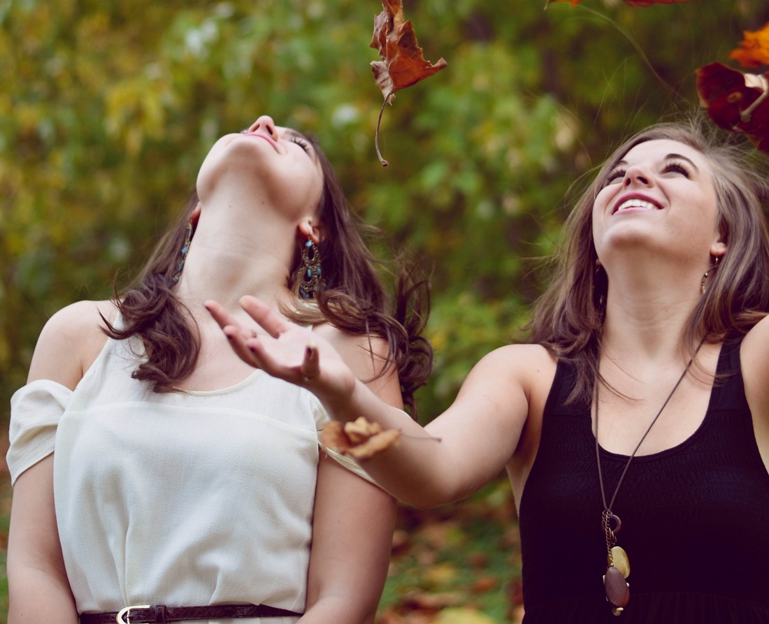 two women with autumn leaves